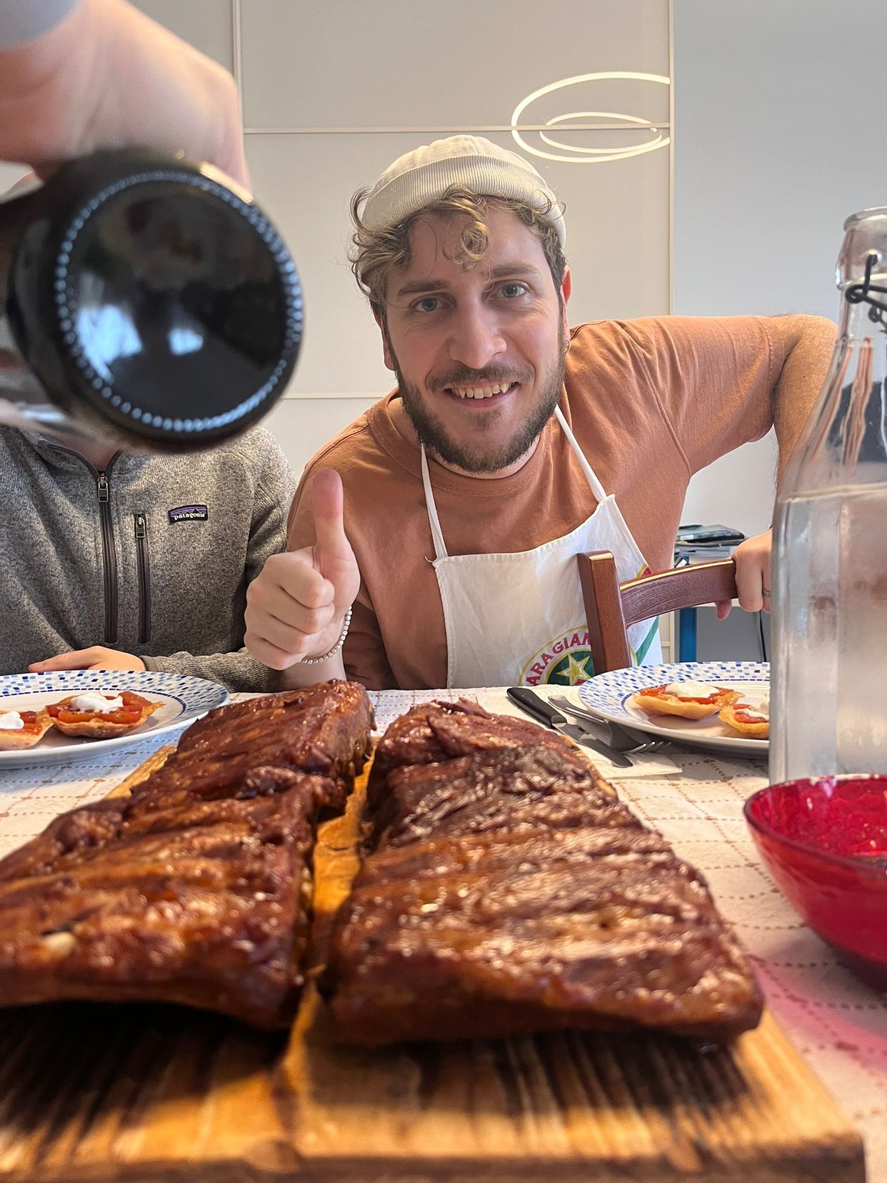 Portrait of a man with brown hair and glasses on a flat gray background.